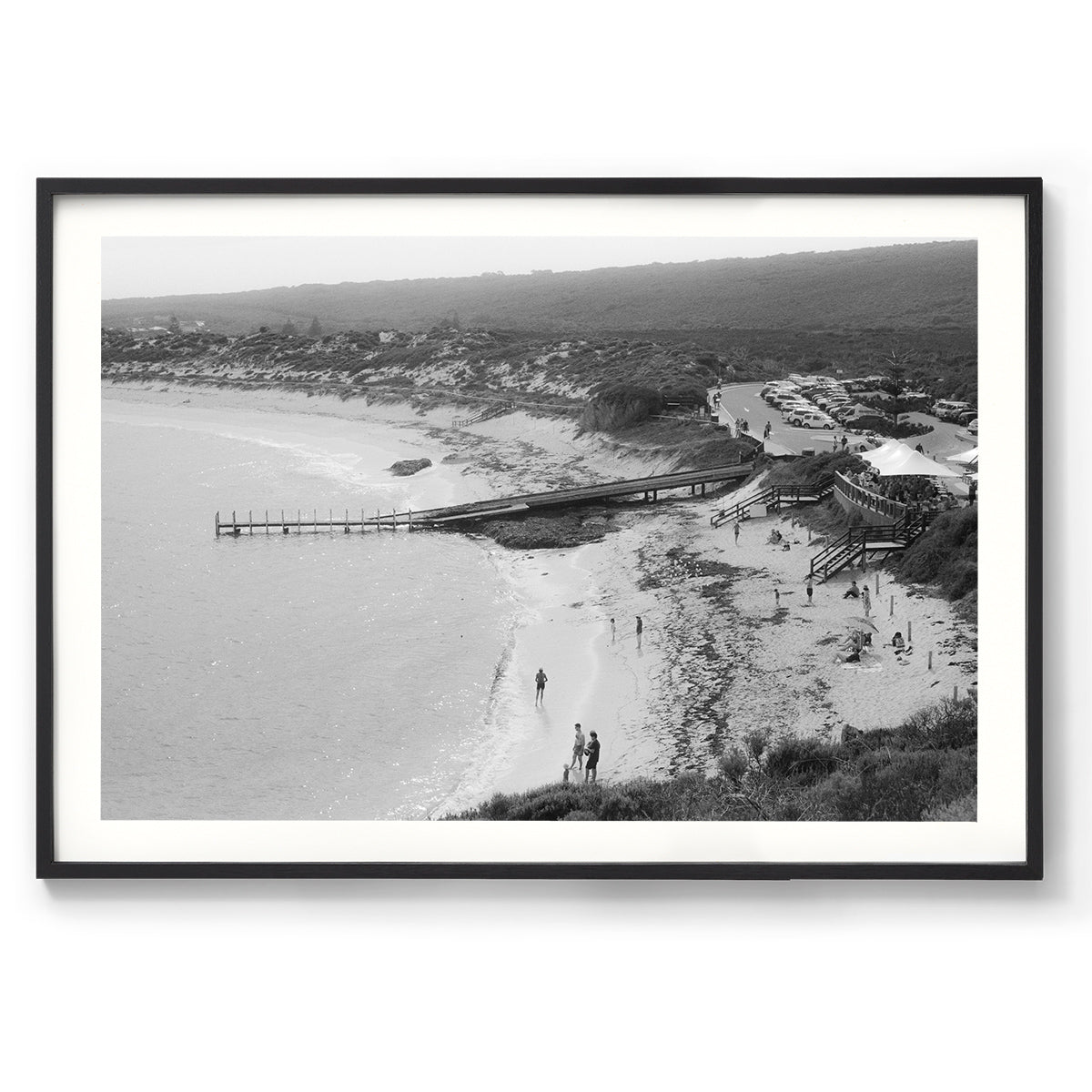 Black and white photo of Gnarabup beach in Margaret River, Western Australia. It shows the jetty and White Elephant Cafe and people on the sand, it has a nostalgic feel to it - shot on film.