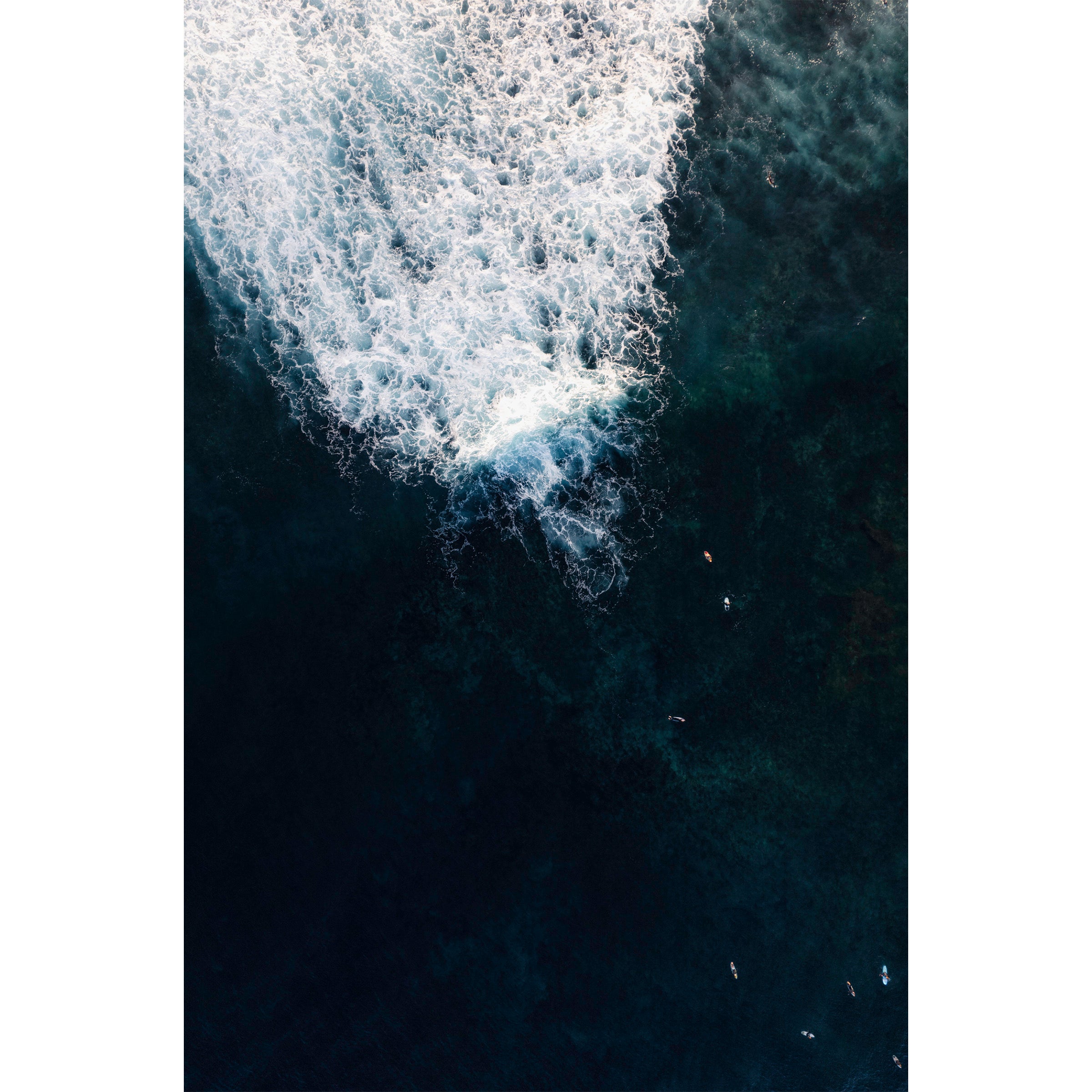 Vertical aerial photo of surfers in deep blue water at Yallingup beach, Western Australia. Perfect for a coastal home or beach house. Original fine art photography, available as prints and framed wall art.