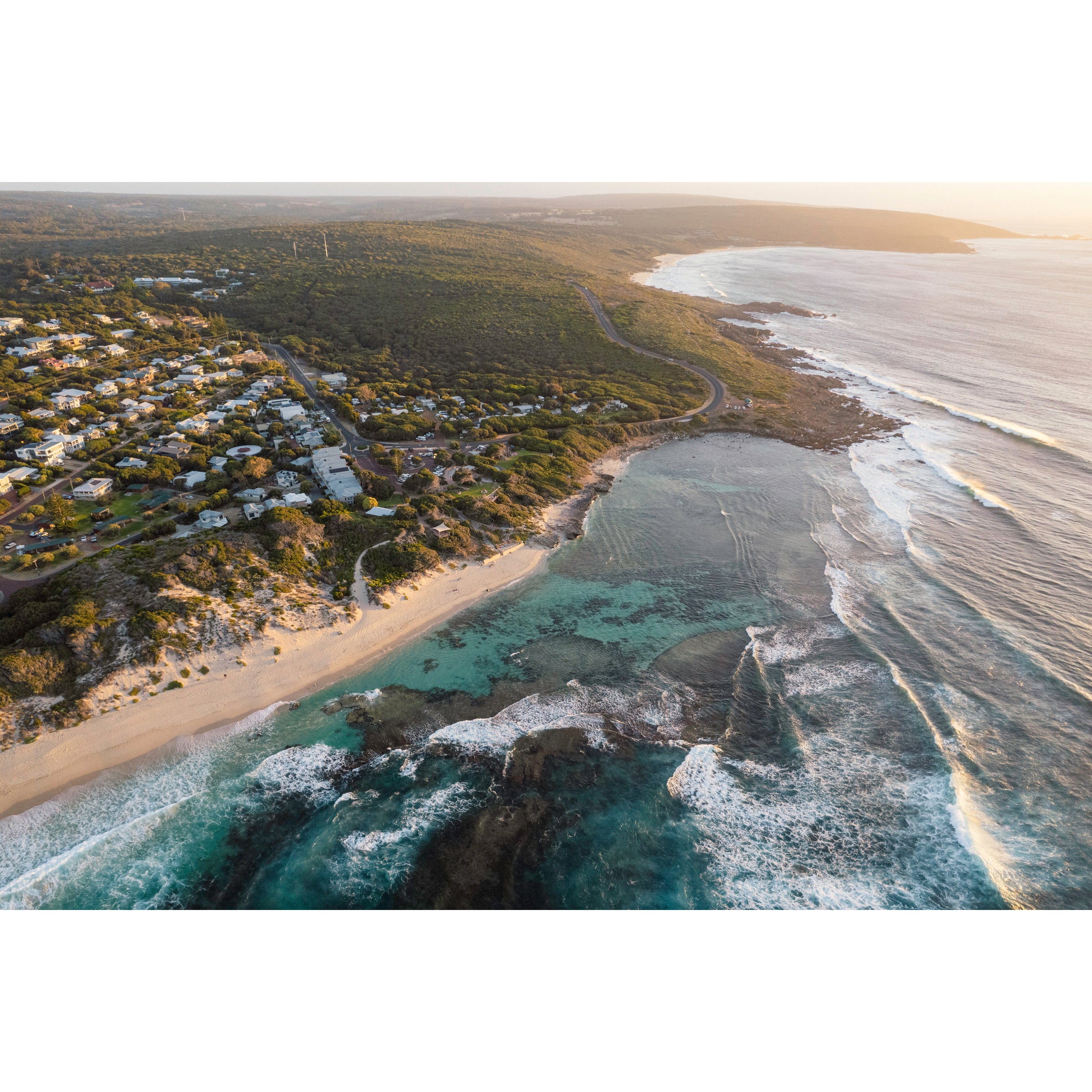 Horizontal drone photo of Yallingup beach and town in Western Australia, taken from above the ocean looking towards the south as the bush stretches into the distance. Original fine art photography, available as prints and framed wall art.