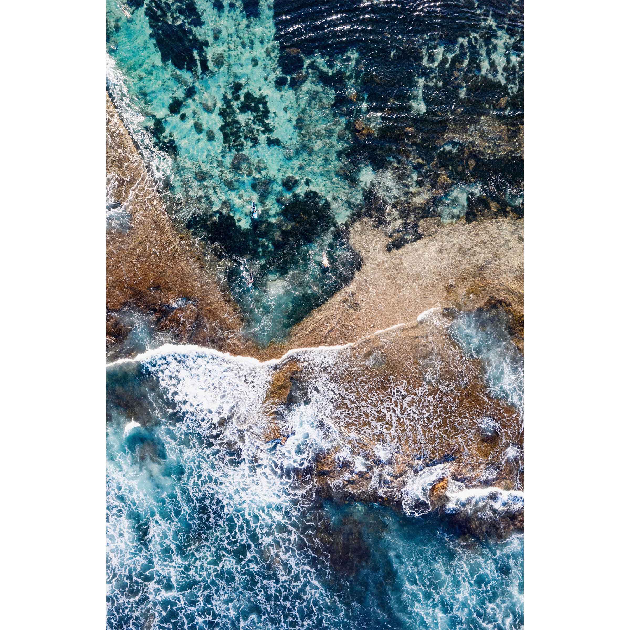 Vertical drone photo taken at Yallingup beach in Western Australia. Shot straight down to show an abstract image of rocks, dark blue water, white swell and turquoise ocean. Coastal wall art perfect for your beach house living room, dining room, bedroom or home office.