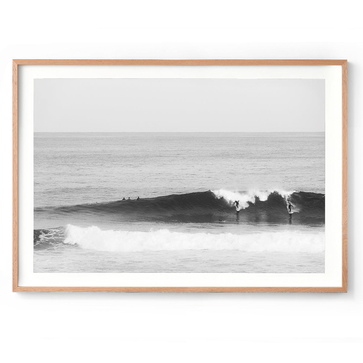 Black and white photo of two surfers riding a wave in the ocean at Surfer's Point, Margaret River, Western Australia. Fine art photography print, available framed in black, white or oak.
