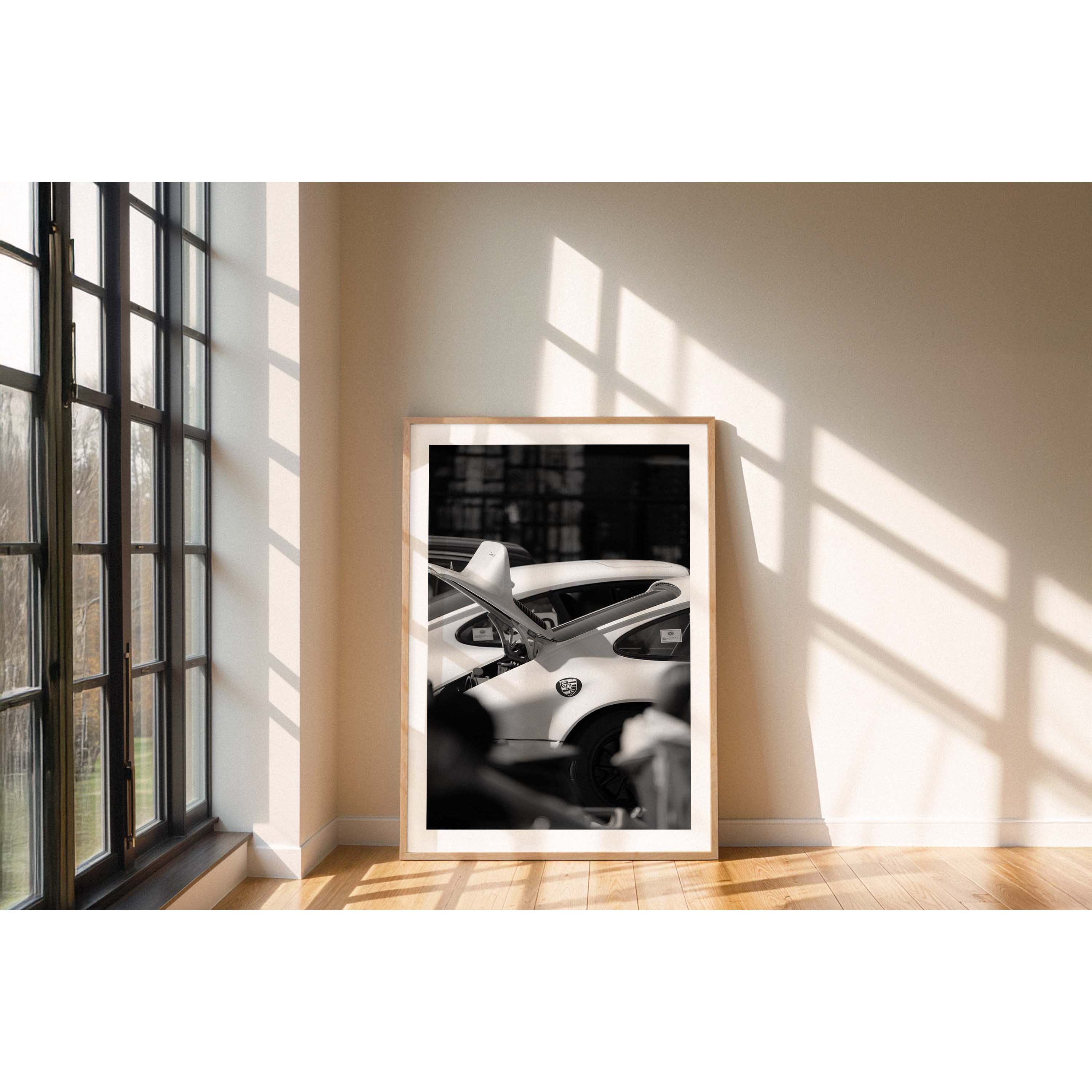 Black and white framed photograph of a Porsche 911 with its boot open waiting to race again. Fine art photography prints, available framed in black, white or oak.