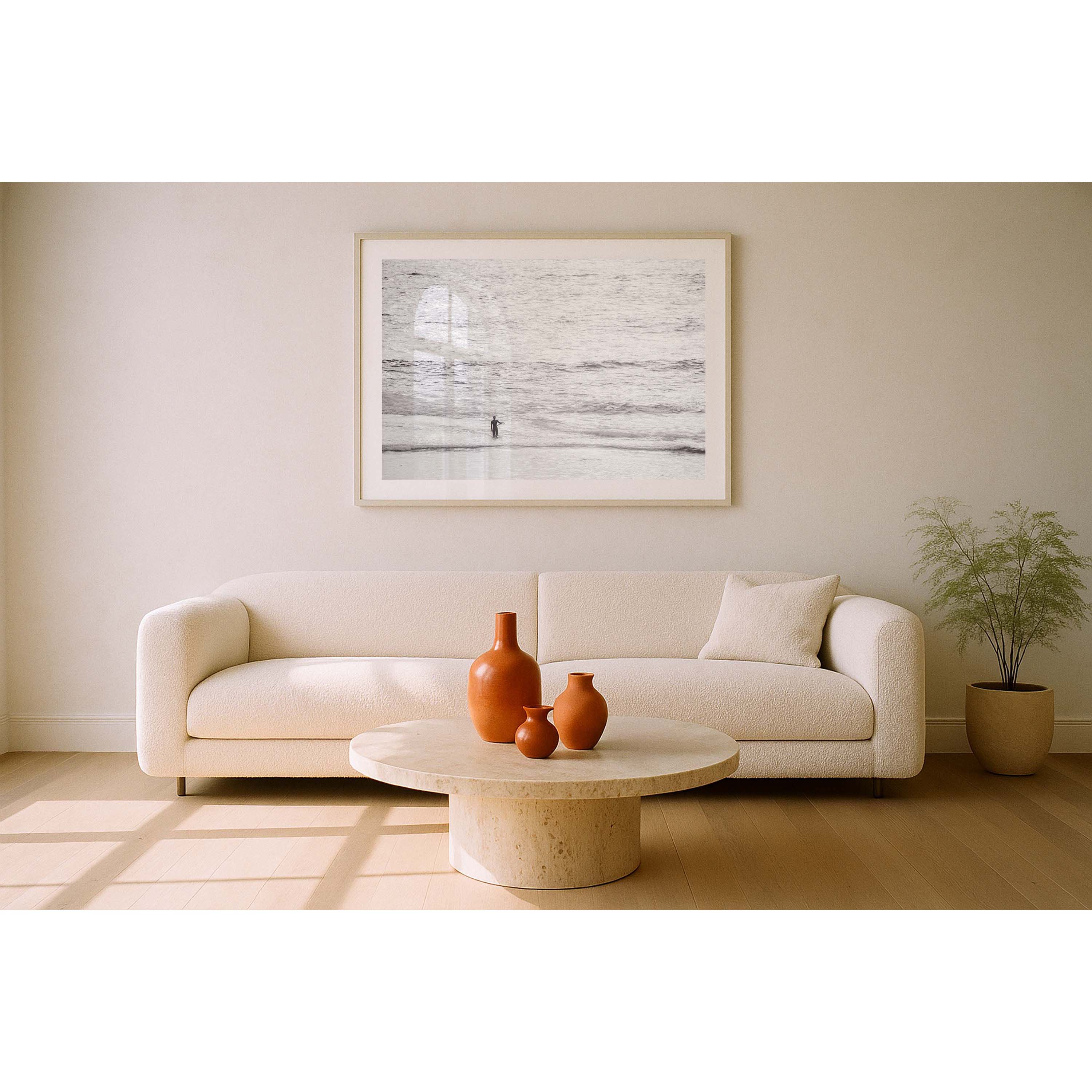 Black and white photo of a female surfer holding a surf board on her hip looking out whilst standing in the ocean at Yallingup Beach. Fine art photography prints, available framed in black, white or oak.