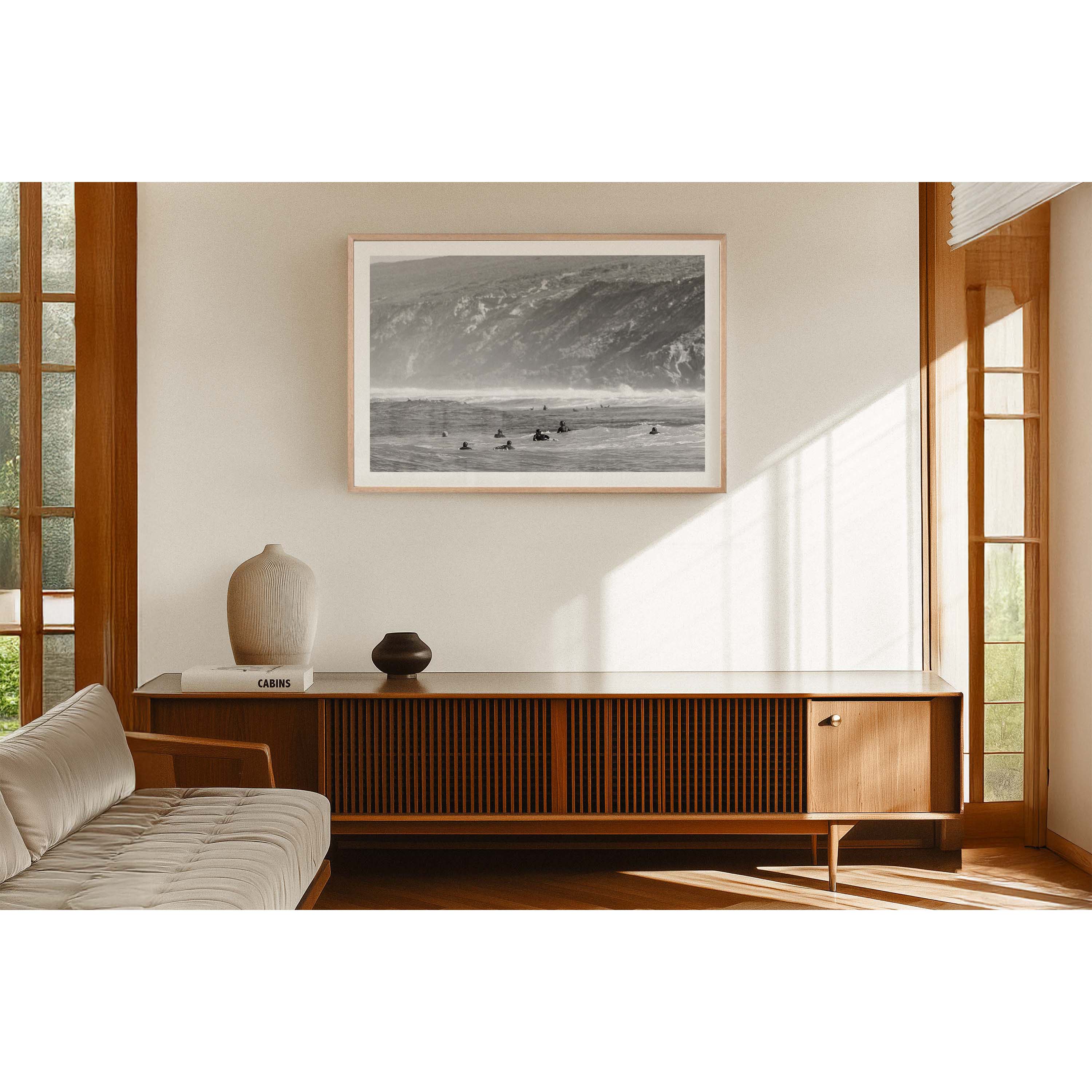 Black and white photo of surfers paddling in the ocean at Yallingup Beach with Rabbit Hill in the background. Fine art photography print from Western Australia's south west, available framed in black, white or oak.