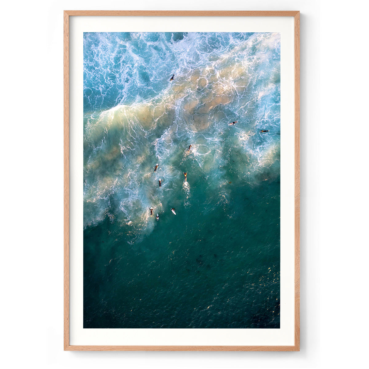 Vertical aerial photo of surfers in the water at sunset at Yallingup beach, Western Australia. The swell is lit up by the golden sunlight as the surfers are dotted through the water. Perfect for a coastal home or beach house. Original fine art photography, available as prints and framed wall art.