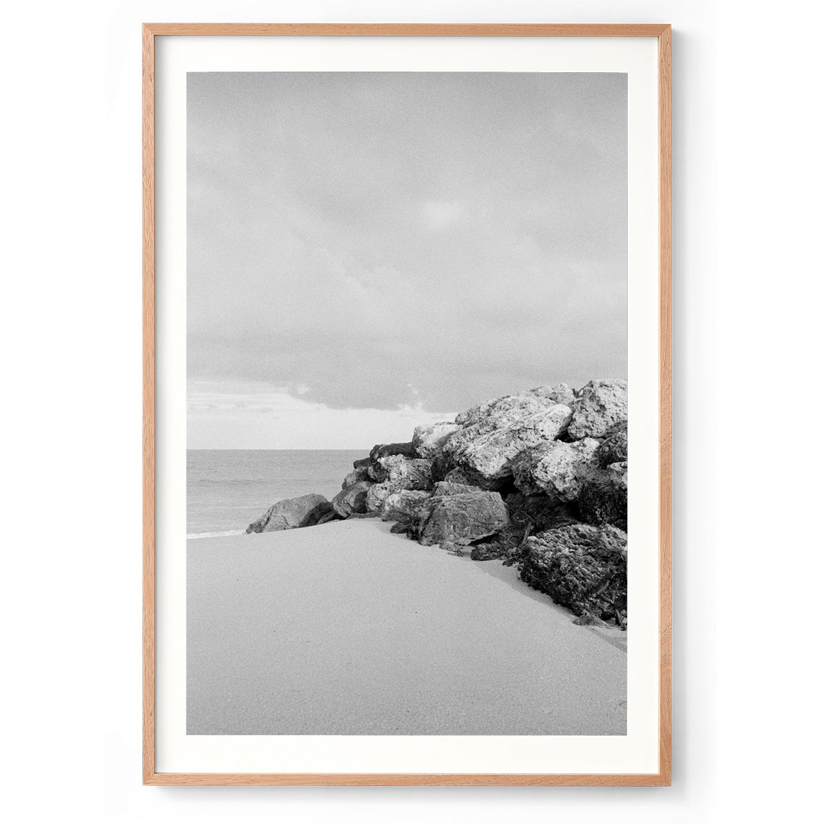 Vertical black and white photo shot on film of some rocks looking out towards the ocean at a beach in Western Australia. Very minimalist and soft. Perfect for a luxury coastal interior or beach house. Available as framed wall art or unframed prints.