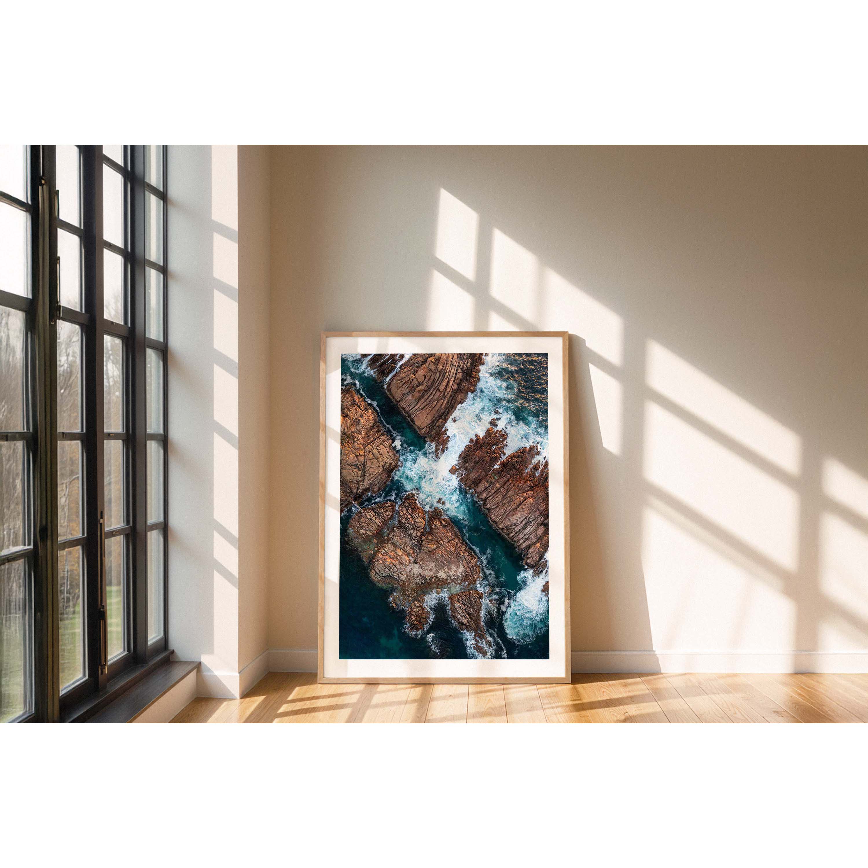 Vertical aerial photo of Canal Rocks in Western Australia near Yallingup. The deep blue ocean is crashing against the rocks creating whitewash that swirls around them. There is a tiny bridge leading from one rock to another on the left hand side. Original fine art photography, available as prints and framed wall art. Perfect for your living room, dining room, bedroom or home office. Shipped free worldwide.