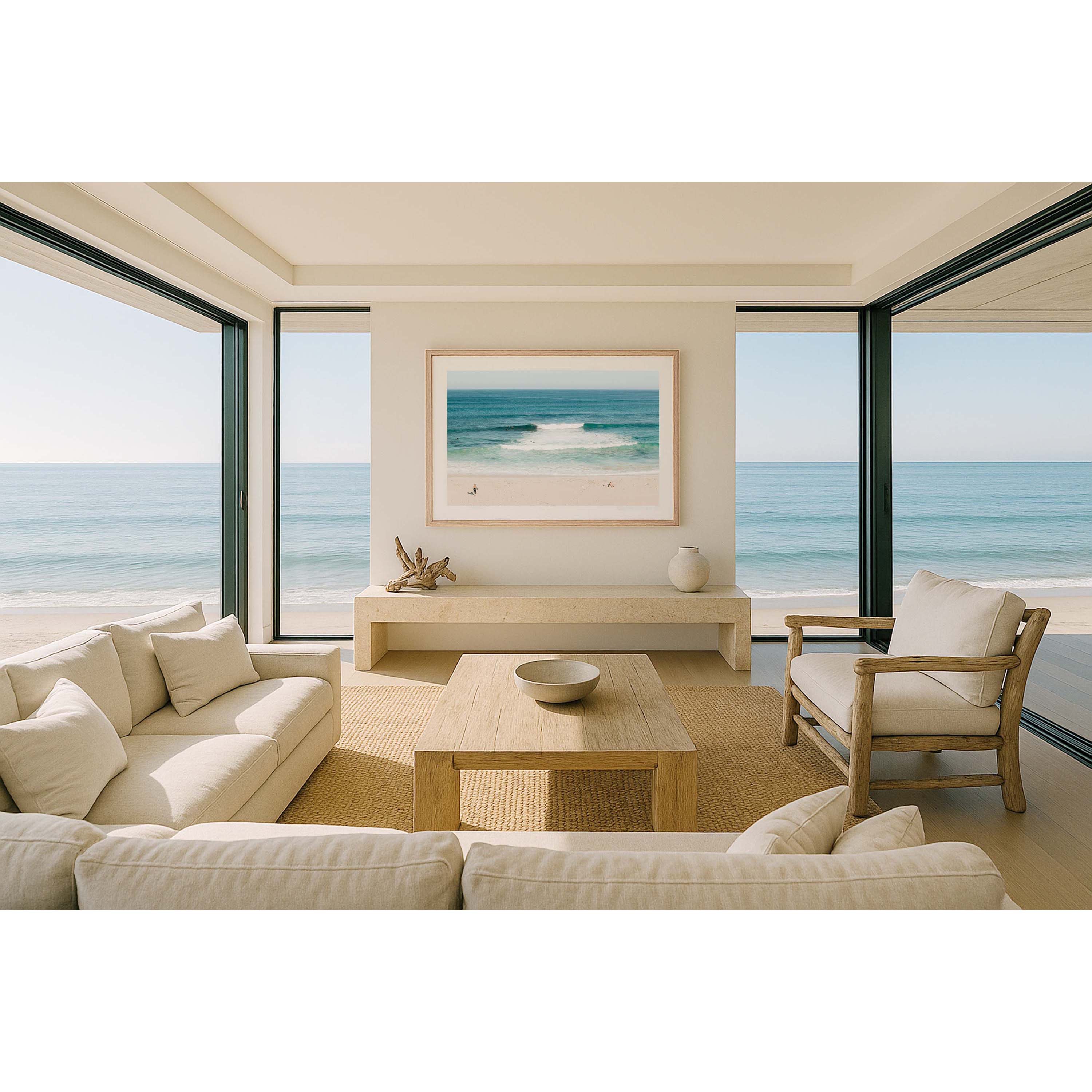 Framed photo of Injidup Beach in Yallingup in Western Australia. There are waves rolling in with surfers dotted through the ocean and a surfer walks across the sand to the water with a surfboard under his arm as a girl sunbathes. Available framed in black, white or oak.
