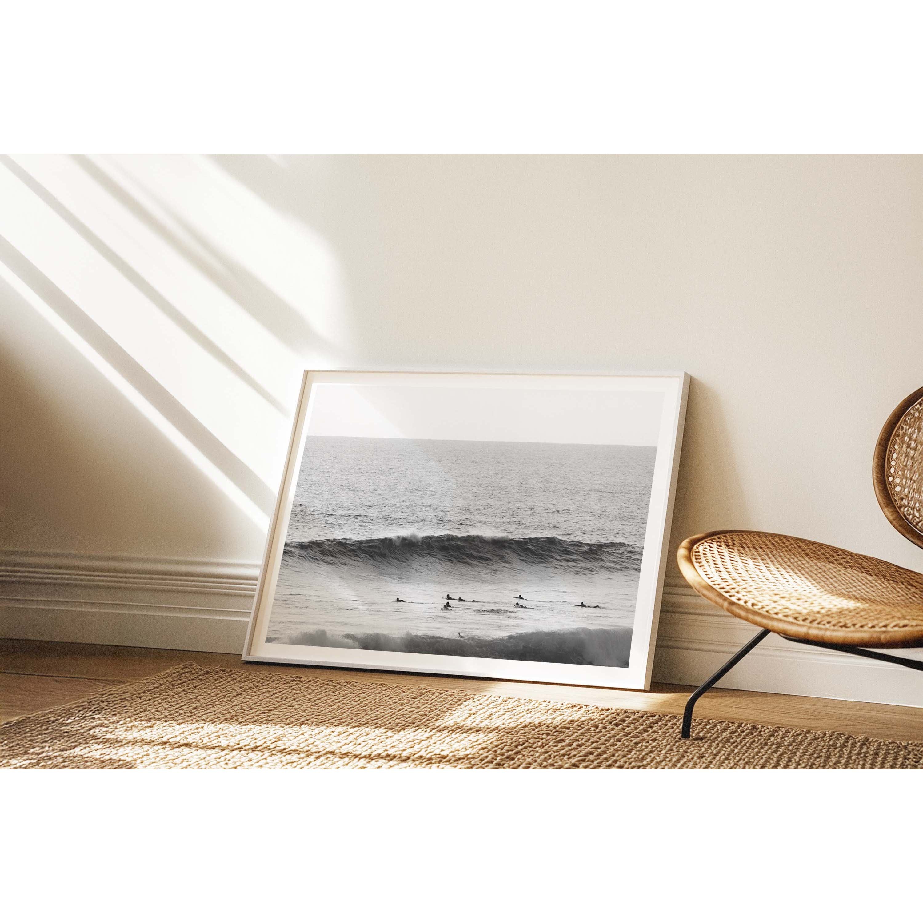 Minimalist black and white photo of surfers paddling out towards a wave in the ocean at Yallingup Beach, Western Australia. Fine art photography prints, available framed in black, white or oak.